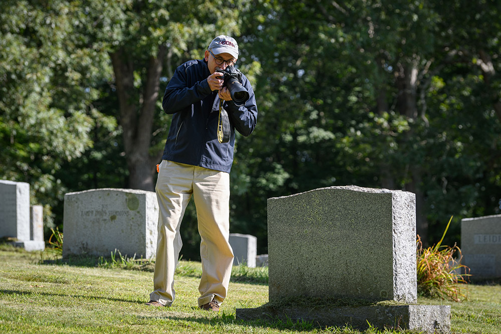 Peter Morenus, the magazine’s photographer, walks through Storrs Cemetery