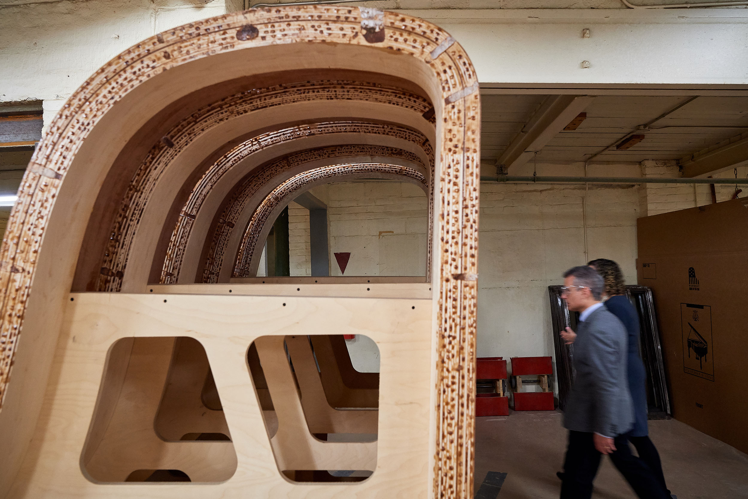 Eric Rice, head of the Department of Music and associate professor of music history, walks past a column of piano rims during a tour of the Steinway & Sons factory