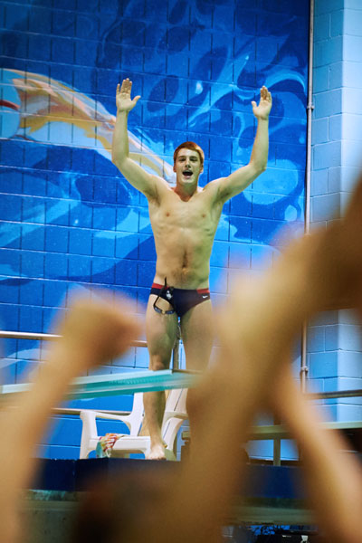UConn swim and dive team, Greg Baliko cheering with hands up
