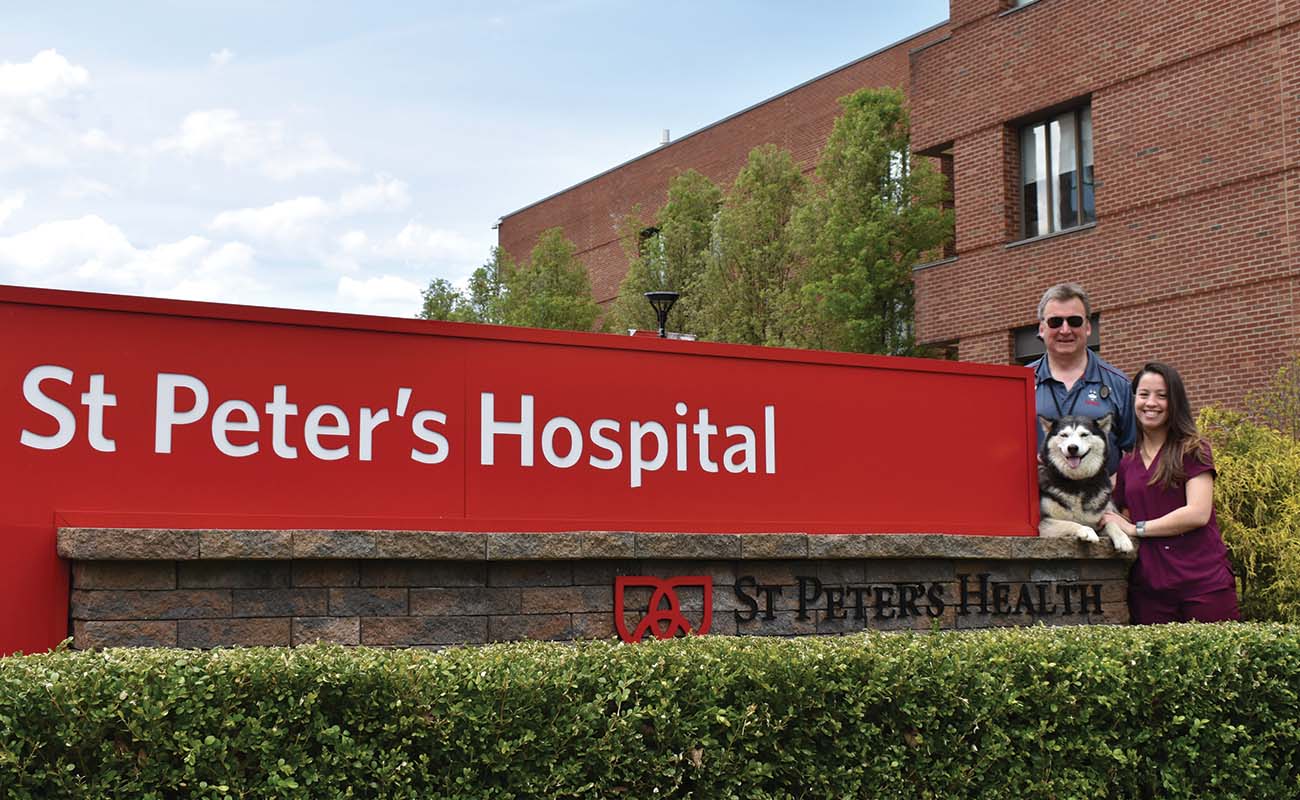 John Powell ’87 (ENG), a hospitalist physician, and Molly Gaffney ’18 (NUR), a registered nurse in in front of the hospital sign at St. Peter’s Hospital in Albany, New York