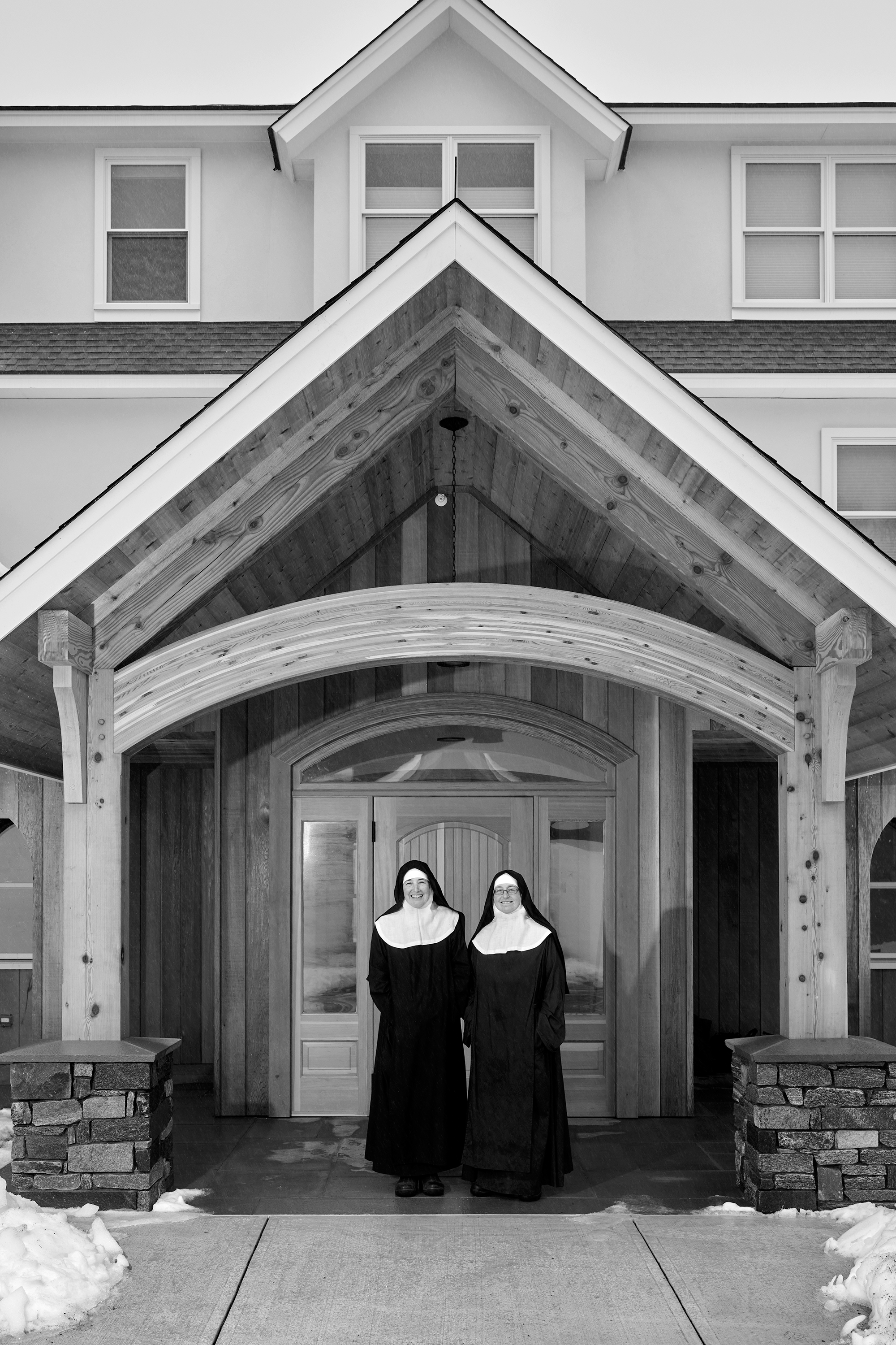 two nuns stand in front of building