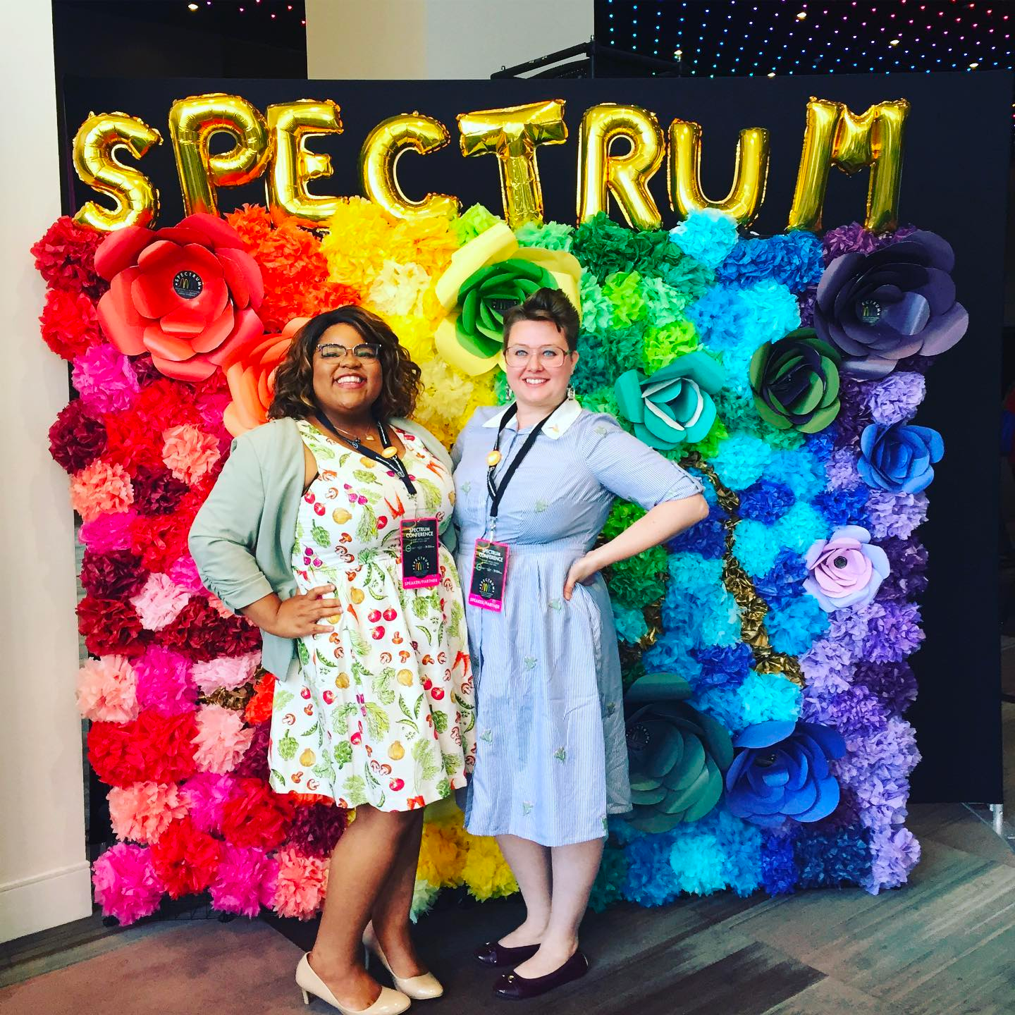 Lauren Todd ’14 (CLAS) and Mick ’15 (CLAS) behinc rainbow wall of flowers