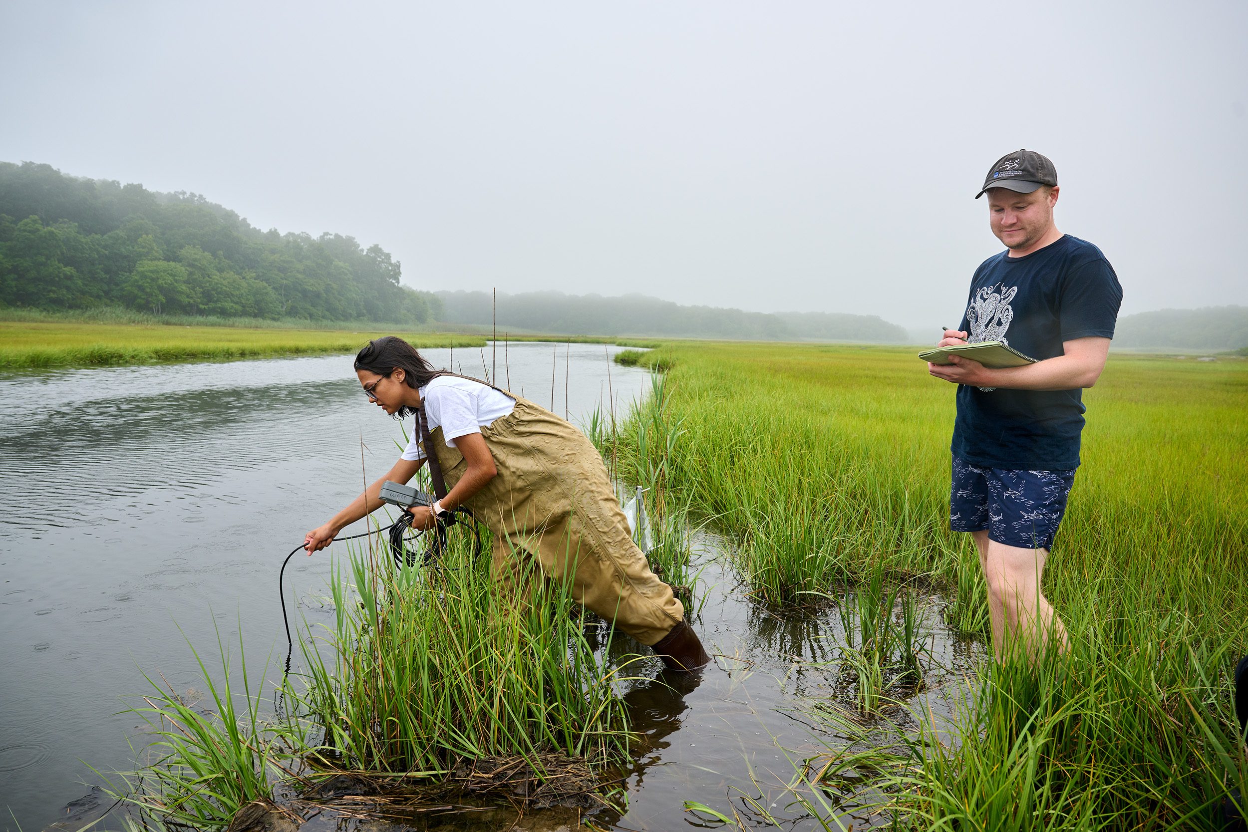 UConn Marine Sciences Ph.D. student Tyler Griffin records the salinity and temperature of a tidal creek