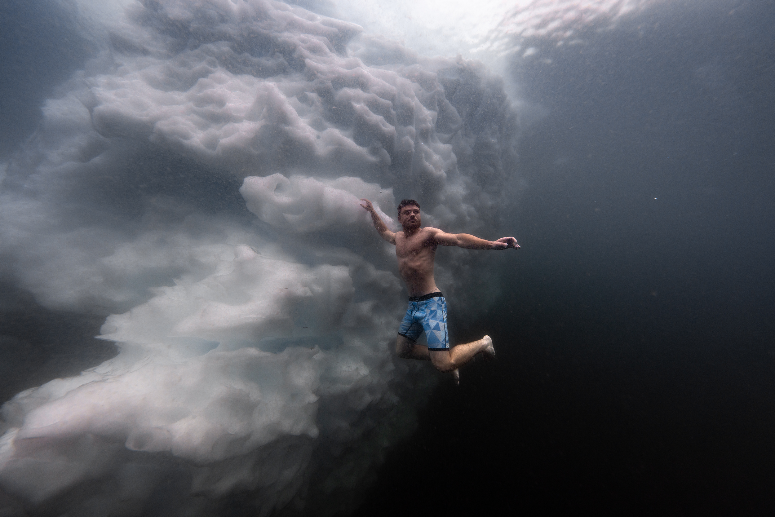 Adams freediving under a glacier with no oxygen tank, wetsuit, or mask — in 28-degree Fahrenheit water.
