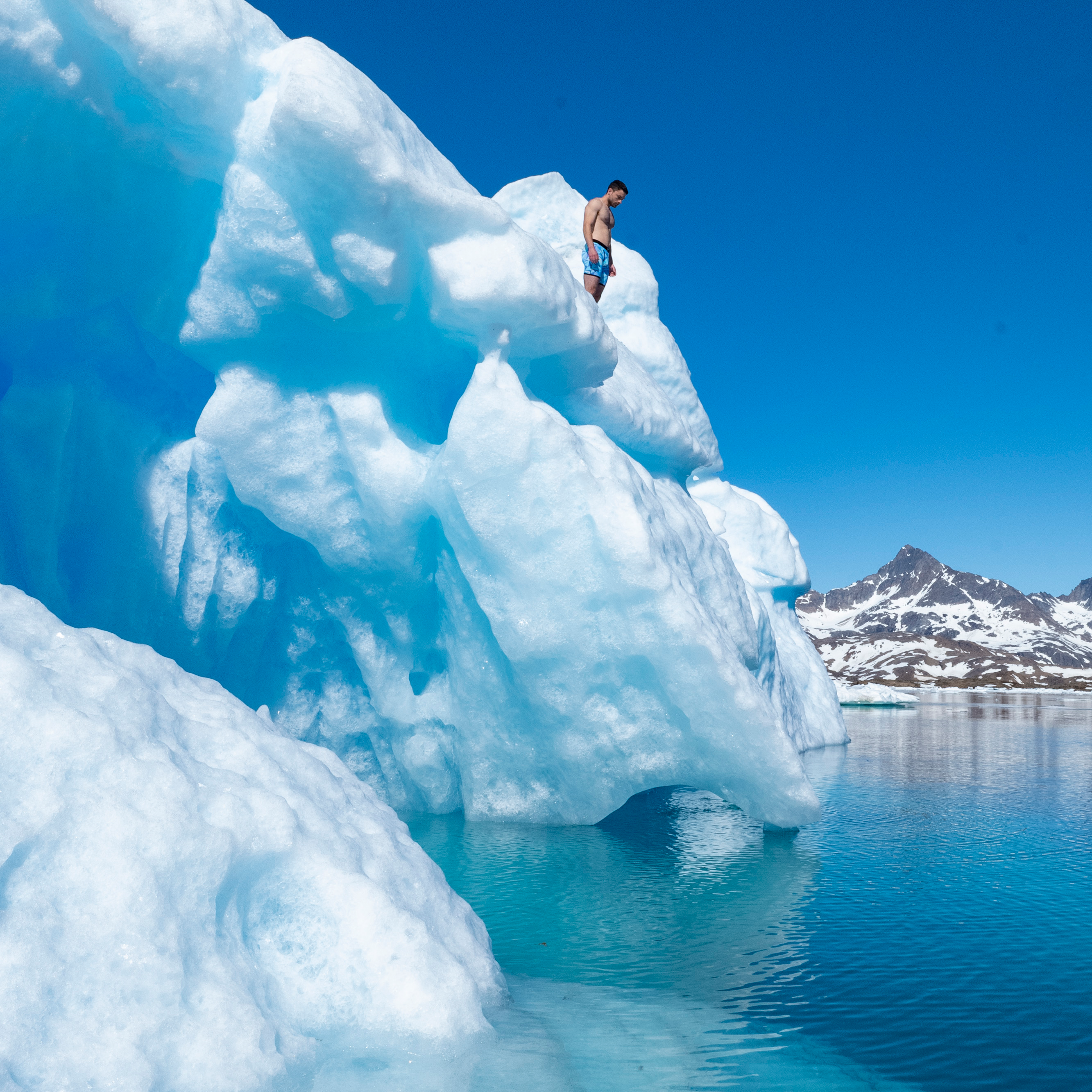 Luke Adams standing barefoot atop this glacier in Greenland