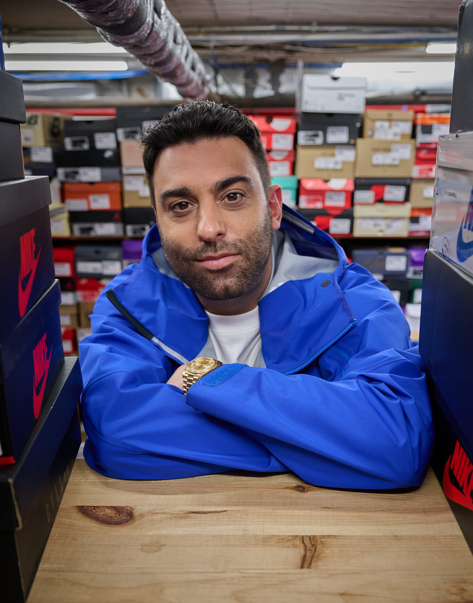 Joe La Puma poses in front of a stock of limited edition and rare sneakers from popular sneak brands, like Nike.