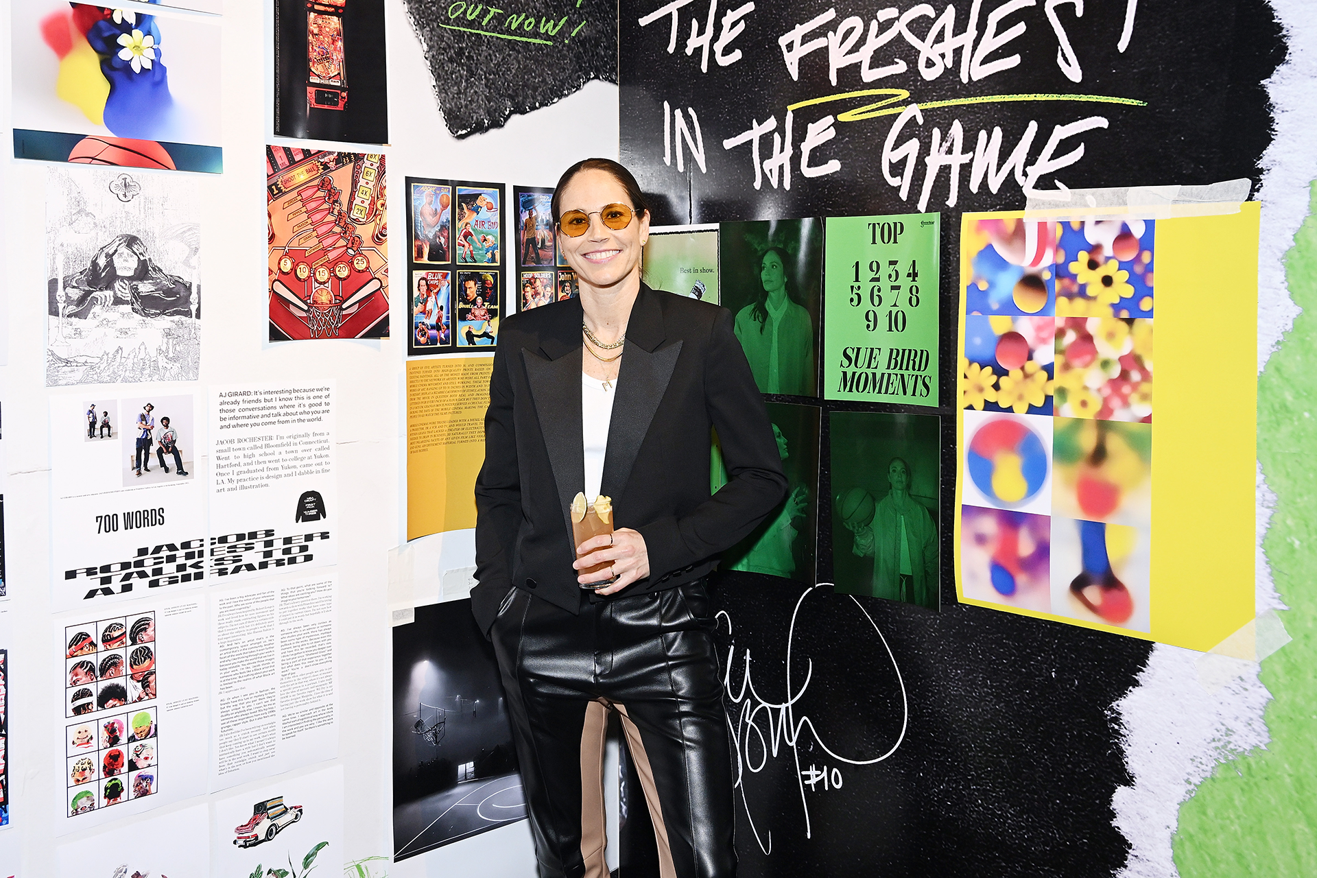 Sue Bird poses in front of Art showcasing her impact in the WMBA during her 2022 WNBA farewell season