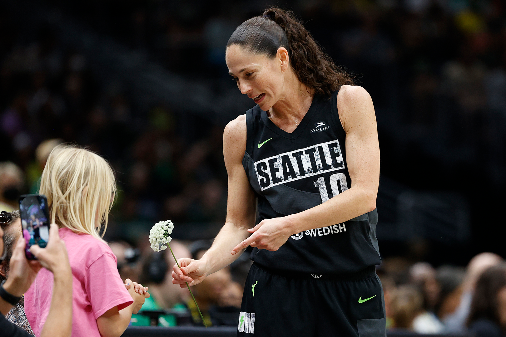SEATTLE, WASHINGTON - AUGUST 07: A fan gives Sue Bird #10 of the Seattle Storm a flower during the first quarter of her last regular season home game of her career against the Las Vegas Aces at Climate Pledge Arena on August 07, 2022 in Seattle, Washington.