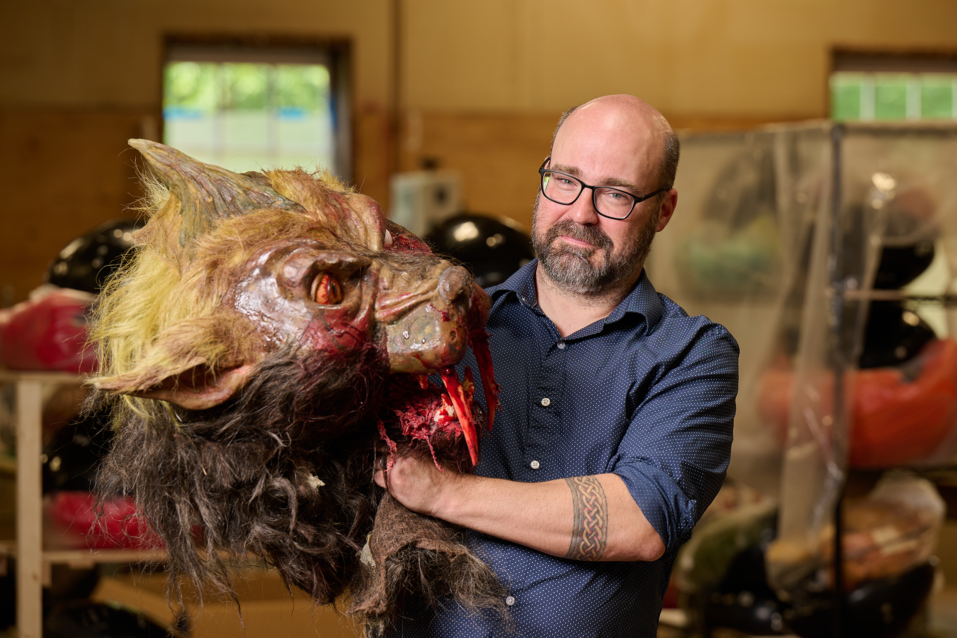 Saunders proudly holds a life-like and bloody chupacabra puppet head.