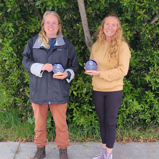 Susan Meiman (left) and Melissa Booker (right) hold award given to them by the U.S. Fish and Wildlife Service for their work.