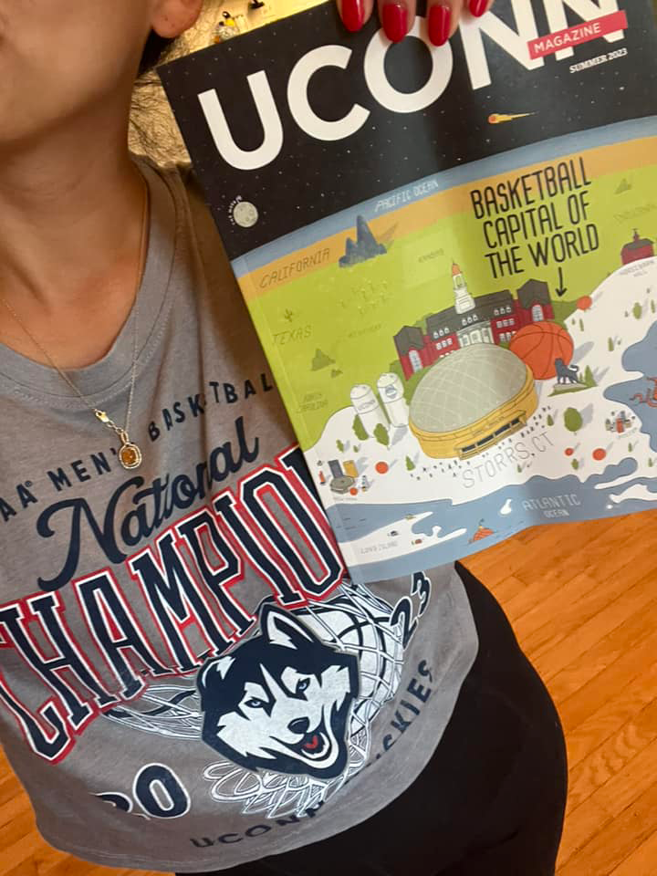 Nicole Ortique ’21 MSW, holds up the special cover edition of UConn Magazine