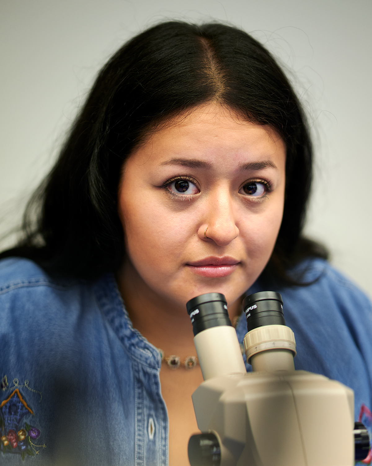 Kate Gavilanes, graduate student, sits at a microscope at the Torrey Life Sciences Building on Dec. 6, 2023. (Peter Morenus/UConn Photo)
