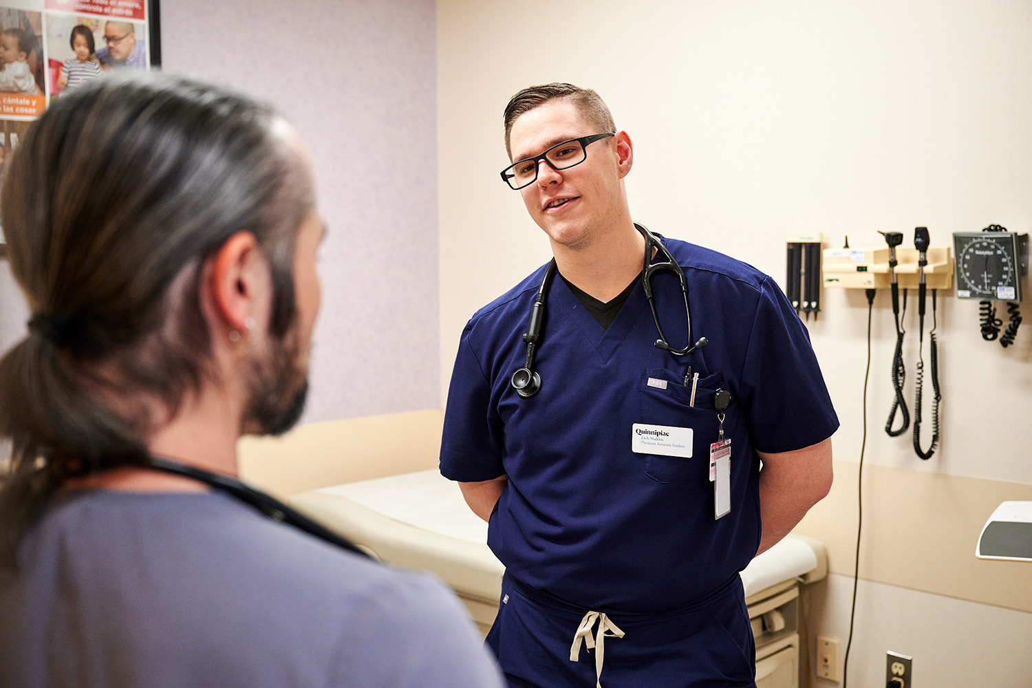Zachary Maddox, right, a physician assistant resident at Optimus Health Care in Bridgeport speaks with Dr. Francois Hayato Coutu on Dec. 14, 2023. (Peter Morenus/UConn Photo)