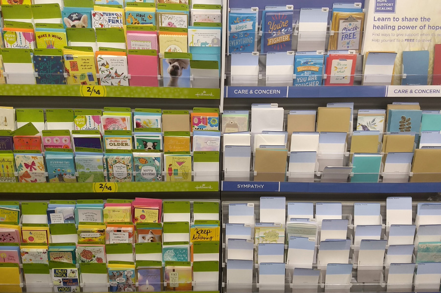 card racks at store showcasing a myriad of birthday and other occasions. The care and concern section is bare and in stark contrast to the happy occasion cards.
