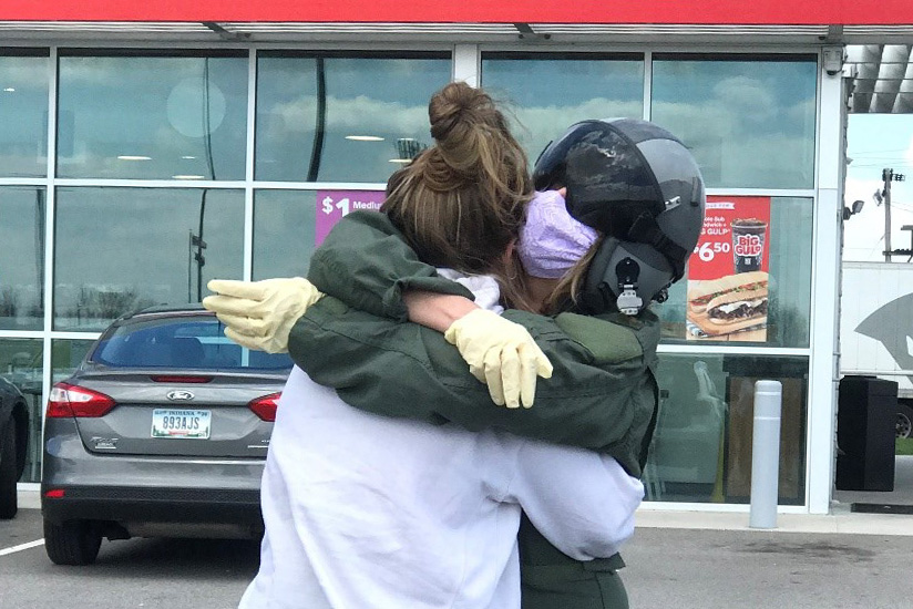 mother and daughter embrace in front of convenience store during the early portion of the pandemic