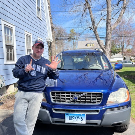 Glenn Marcella stands proudly in front of his vehicle which sports a “Husky 6” vanity license plate.