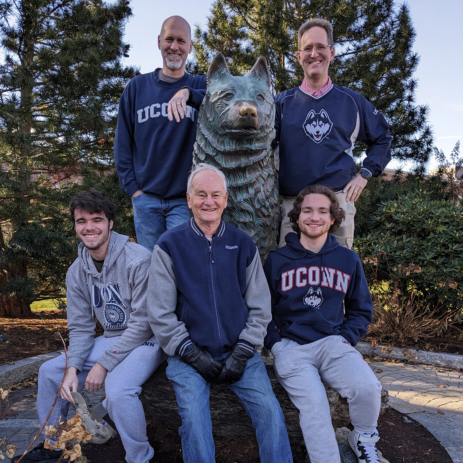 Nelson King of Dayville, Connecticut, sons Kevin King of Plainville, Connecticut, and Tracy King of Halfmoon, New York; and grandsons Zachary King and Robert King pose wearing UConn sweaters pose with the Jonathan statue at UConn Storrs campus.