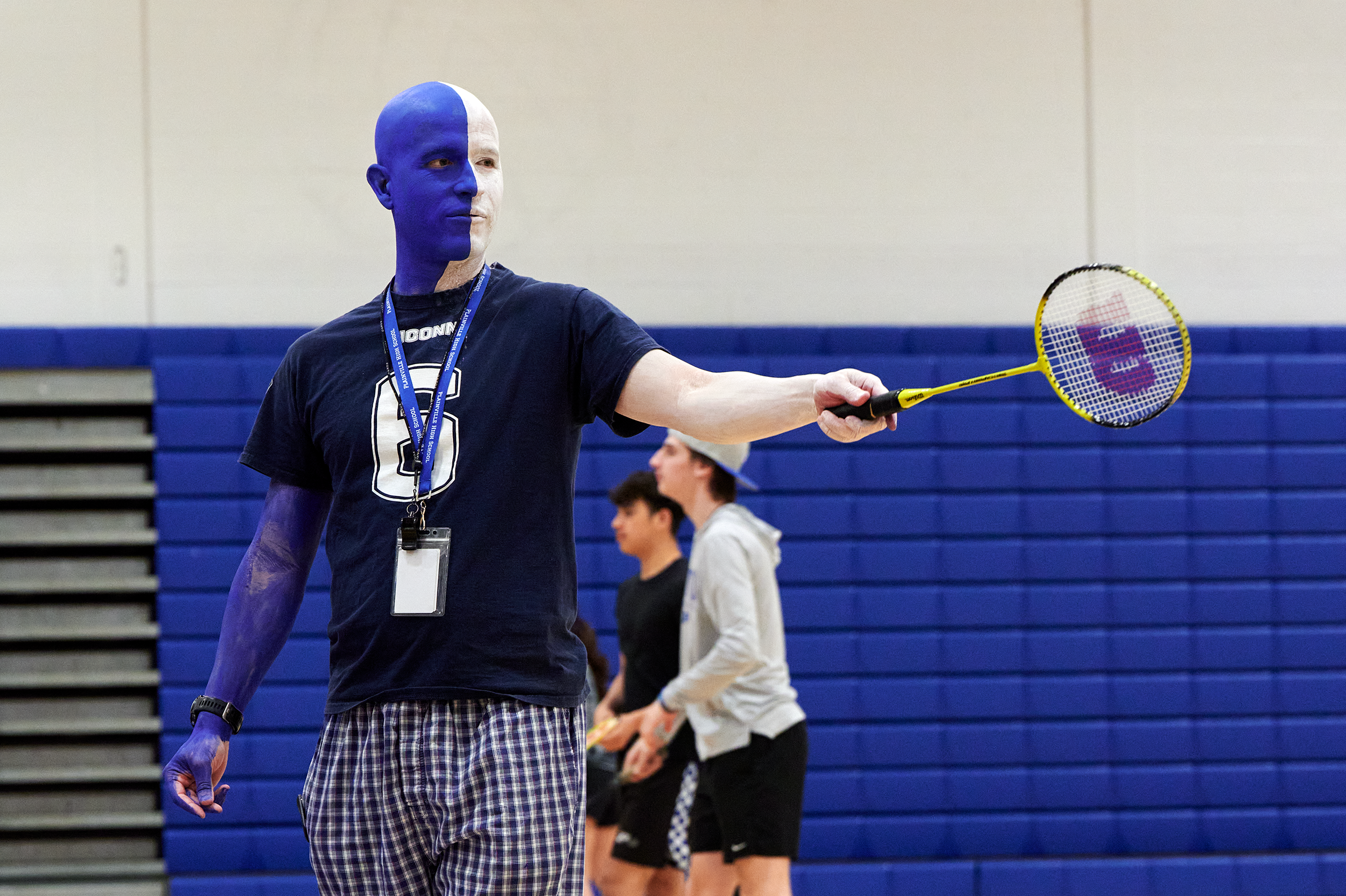 Dale Nosel in blue and white split body paint leads a gym class at Plainville High School