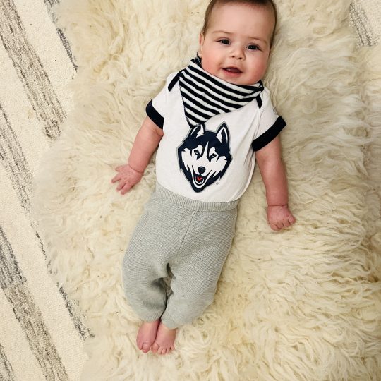 Teddy Rago, 5 months old, in a UConn Husky printed shirt and UConn Blue bandana