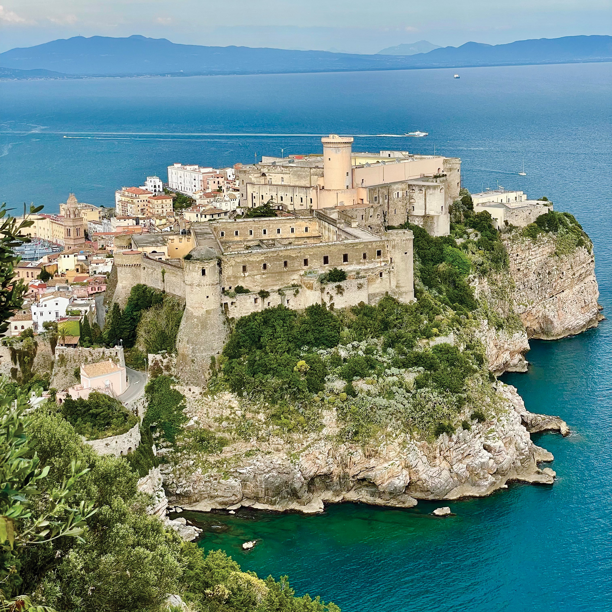 The view from the top of the Old Town of Gaeta. beautiful stonework buildings lay on a peninsula surrounded by blue waters