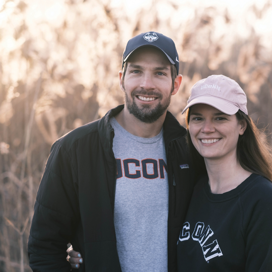 Abbey Forbes and Matt Molgan pose for a photo in a lush wheat field