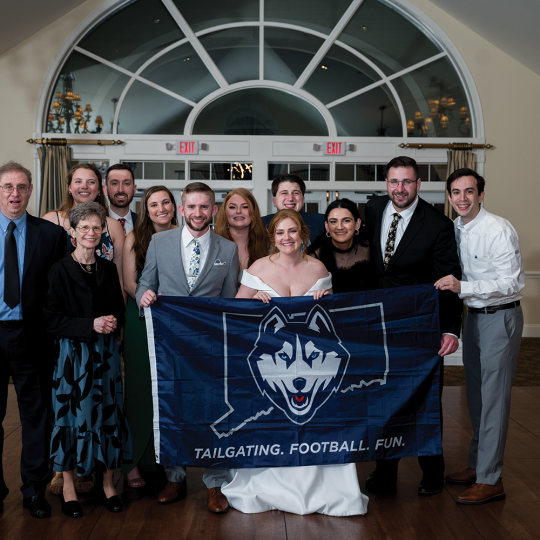 Linder and Gehring wedding party hold a UConn-Connecticut banner