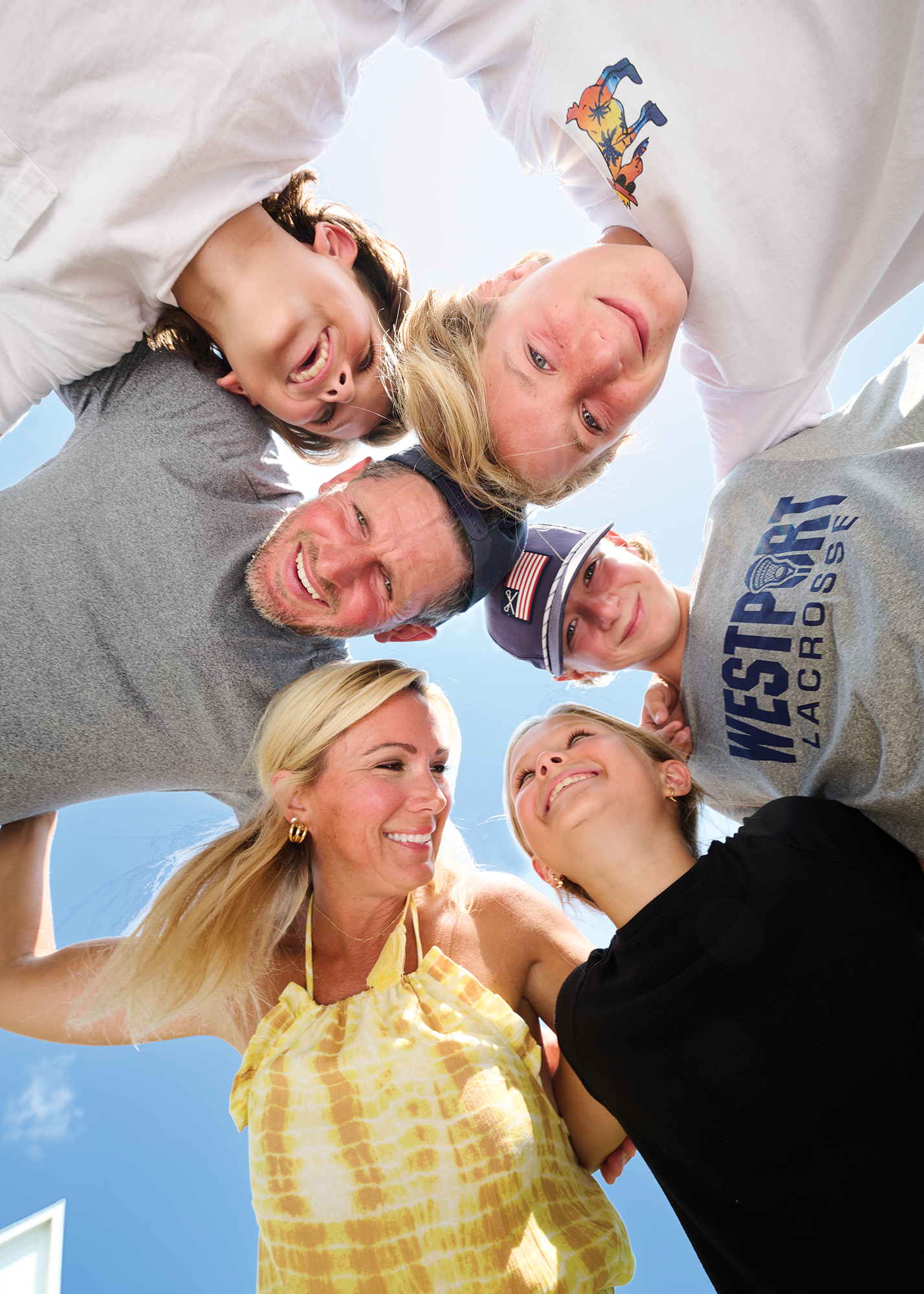 Dan Orlovsky and his family of three young boys and one girl, along with wife, smile and huddle together