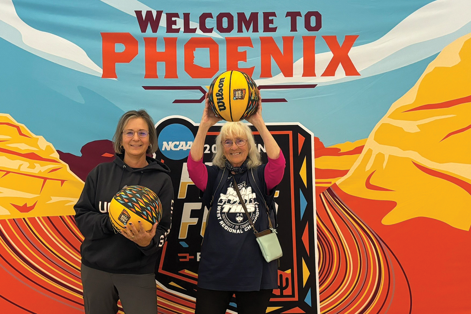 Vanessa and her mother in front of NCAA final four banner that says welcome to pheonix.