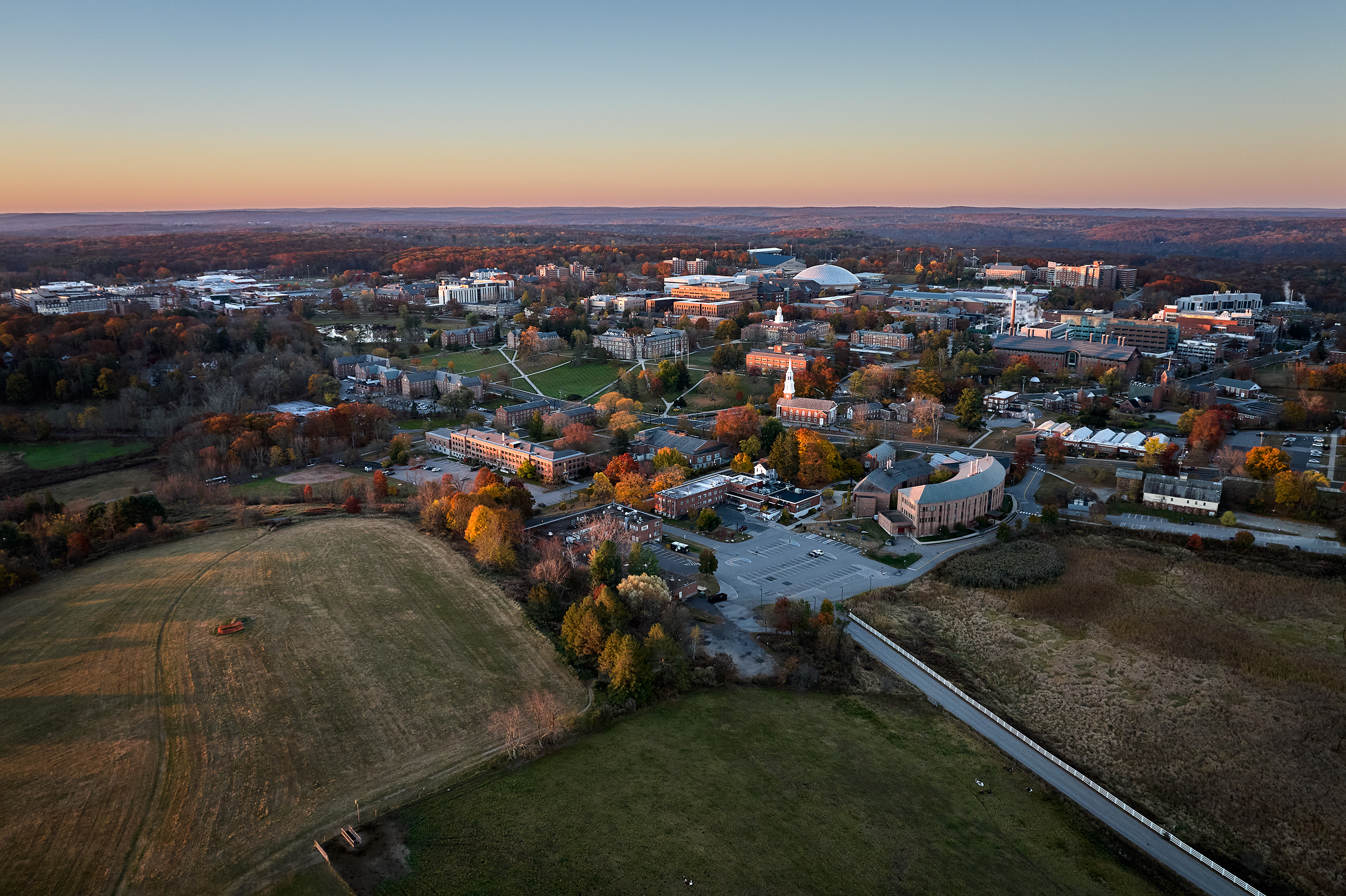 Aerial shot of campus during the day, showing Horsebarn Hill, academic buildings, dorms, dining halls and paths.