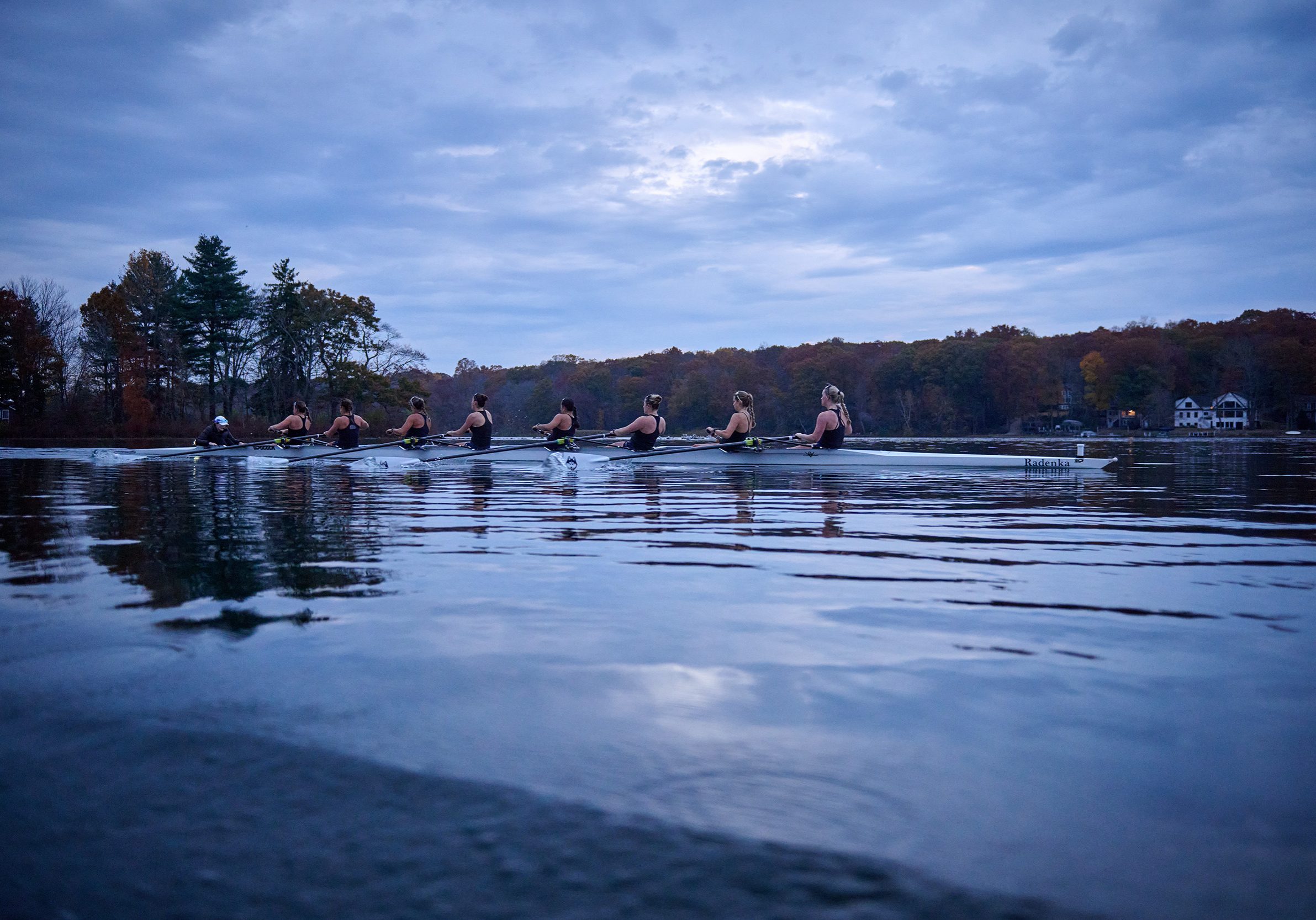 The UConn women’s rowing team practices in Coventry Lake in a sleek white boat named Radenka.