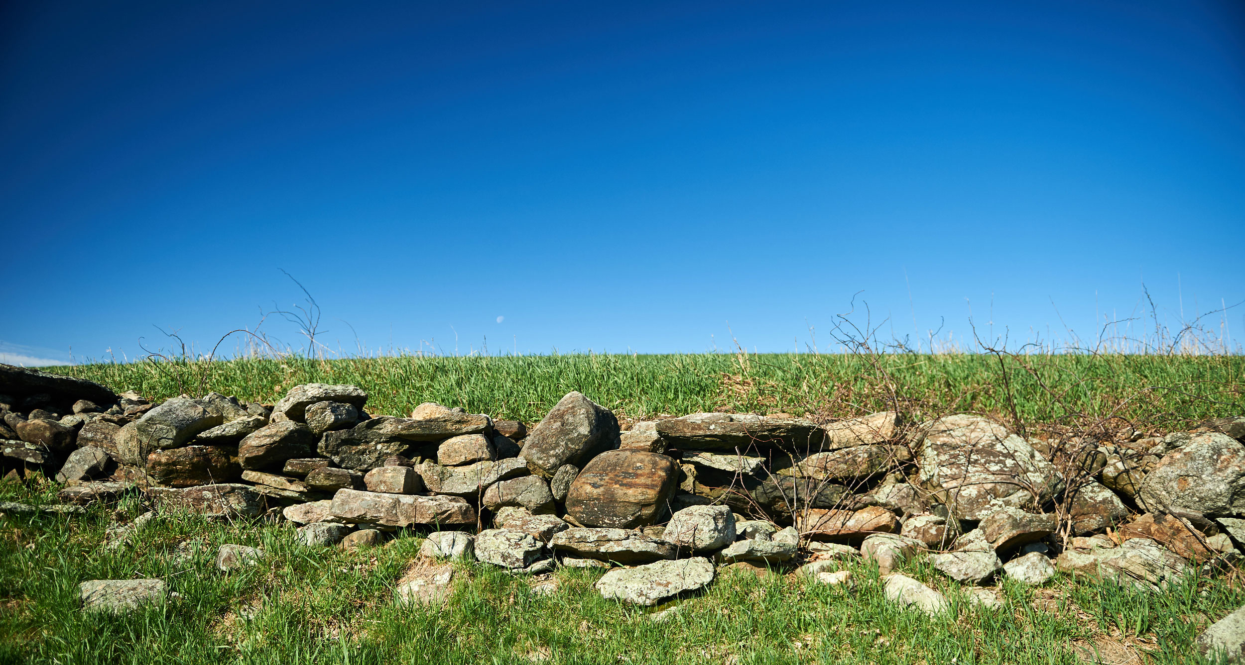 Rock wall in the foreground with bright blue skies