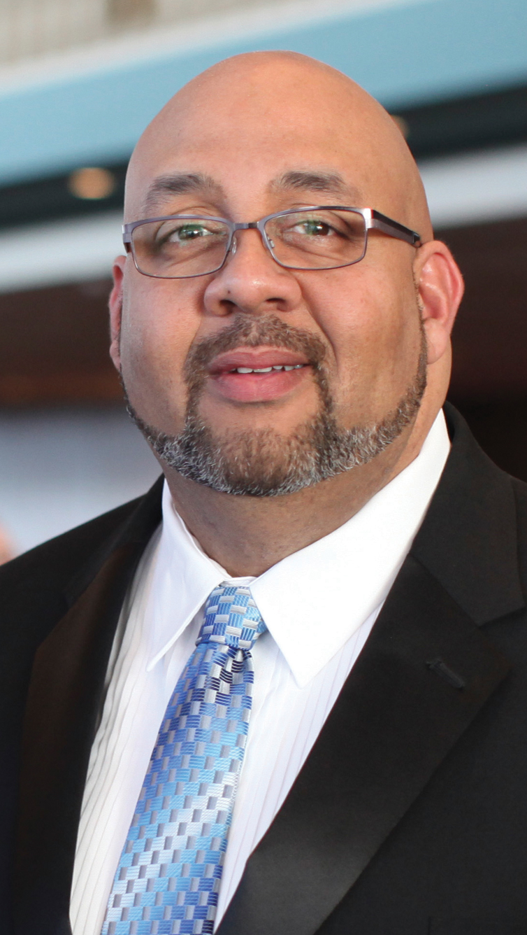 male with trimmed beard suite and blue necktie