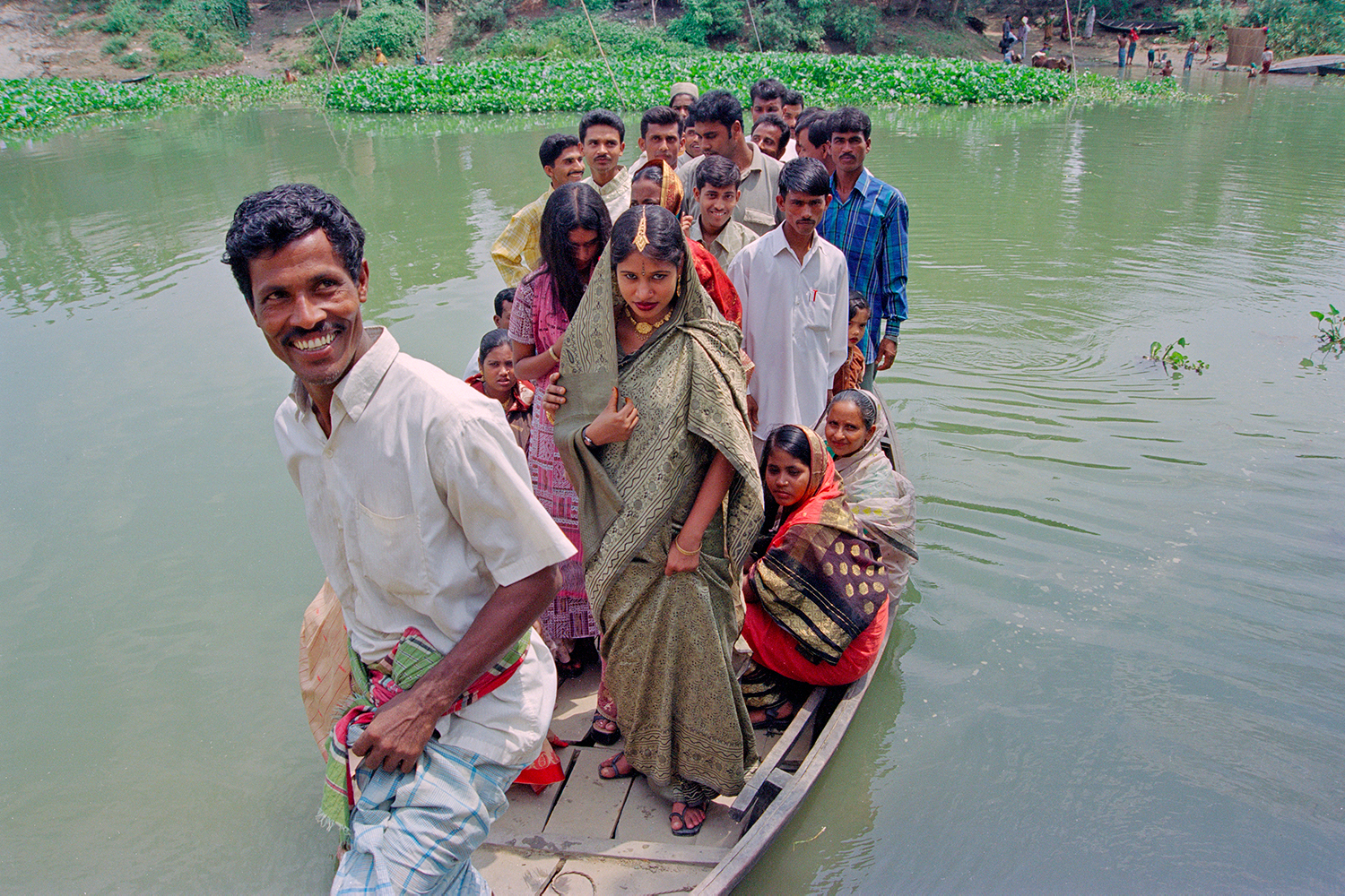 Boatman brings wedding party to riverbank in Narayanganj, Bangladesh, 2004.