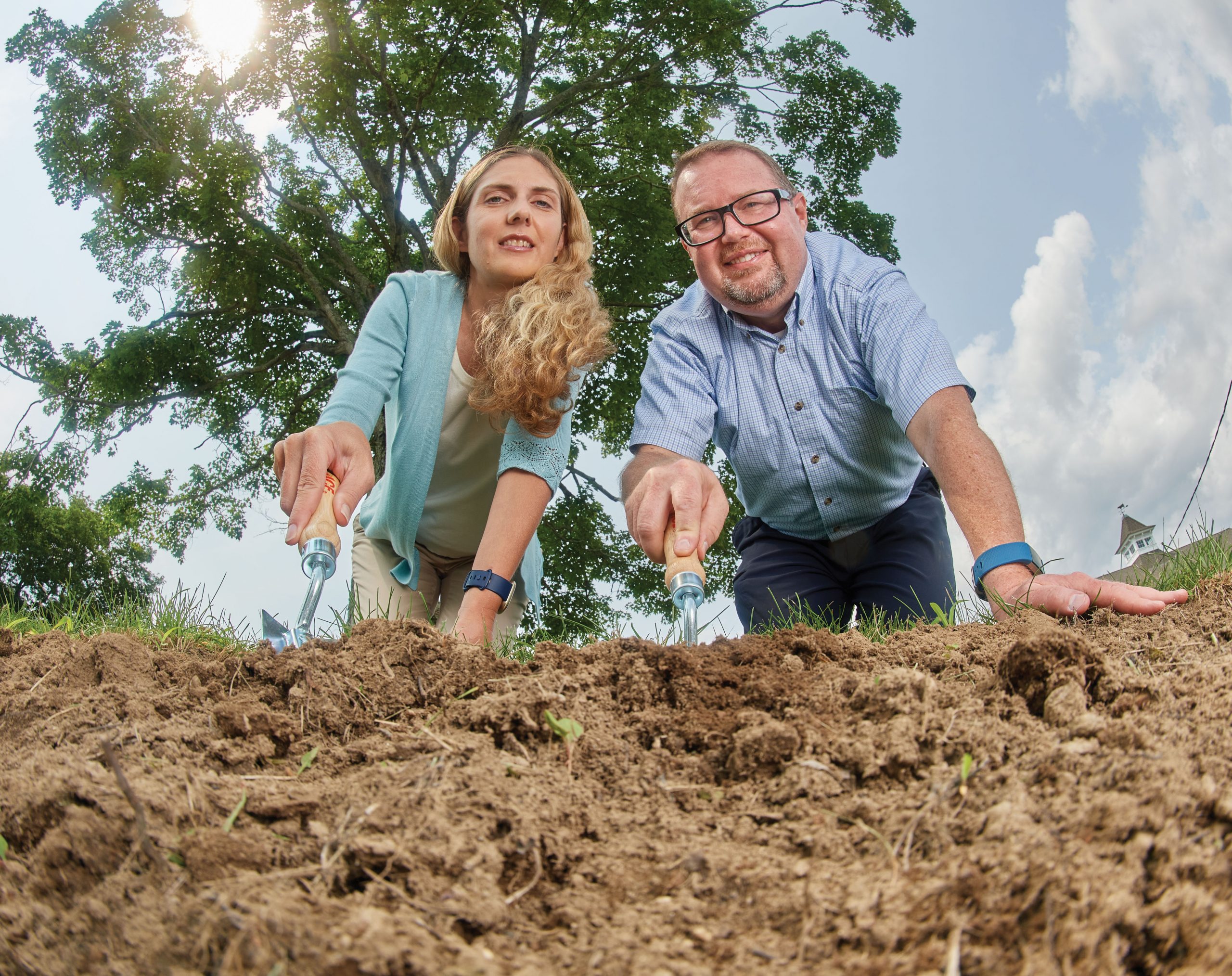 Worm's eye view of Patricia Rossi, left, assistant professor in residence of molecular science and cellular biology, and Spencer Nyholm, associate professor of molecular science and cellular biology, digging dirt