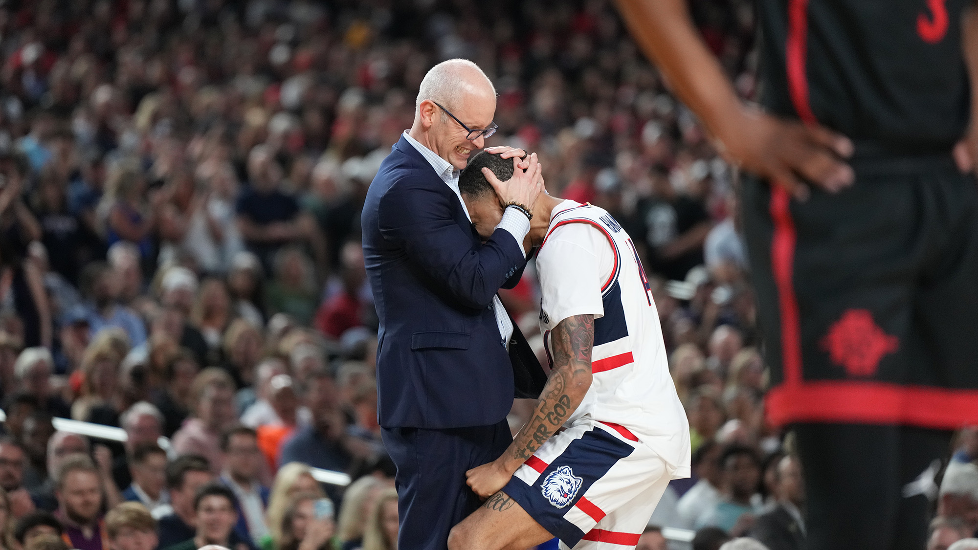 Coach Dan Hurley and Jordan Hawkins embrace moments after the big win