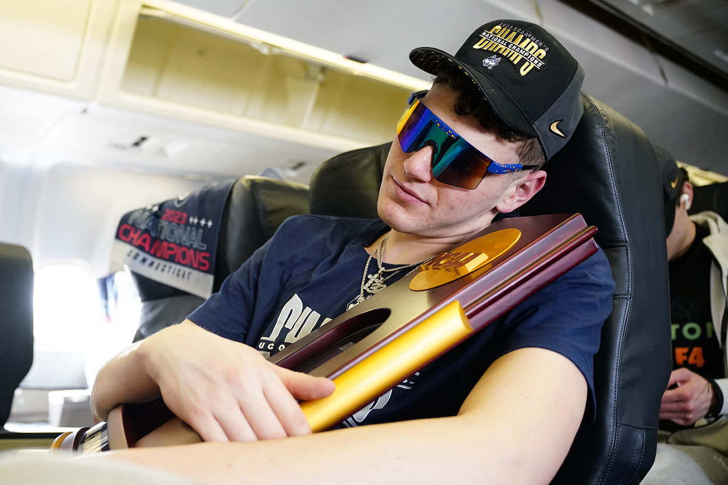 Donovan Clingan clings to the championship trophy during the plane ride home. 