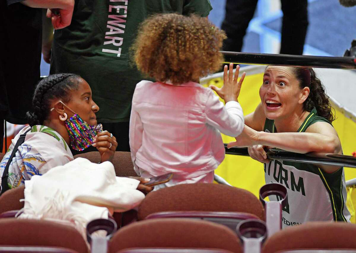 small fan hi-fives Sue Bird during a basketball game