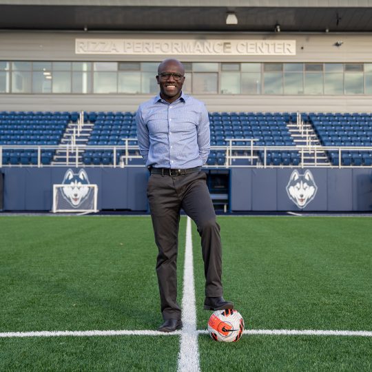 Chris Gbandi poses with soccer ball at Rizza Performance Center green