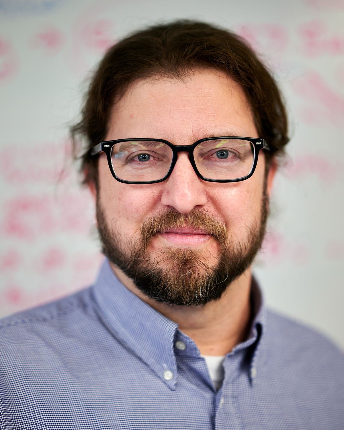 Geoffrey Tanner, assistant professor in residence of physiology and neurobiology, stands near a whiteboard covered with equations at the Torrey Life Sciences Building on Dec. 6, 2023. (Peter Morenus/UConn Photo)