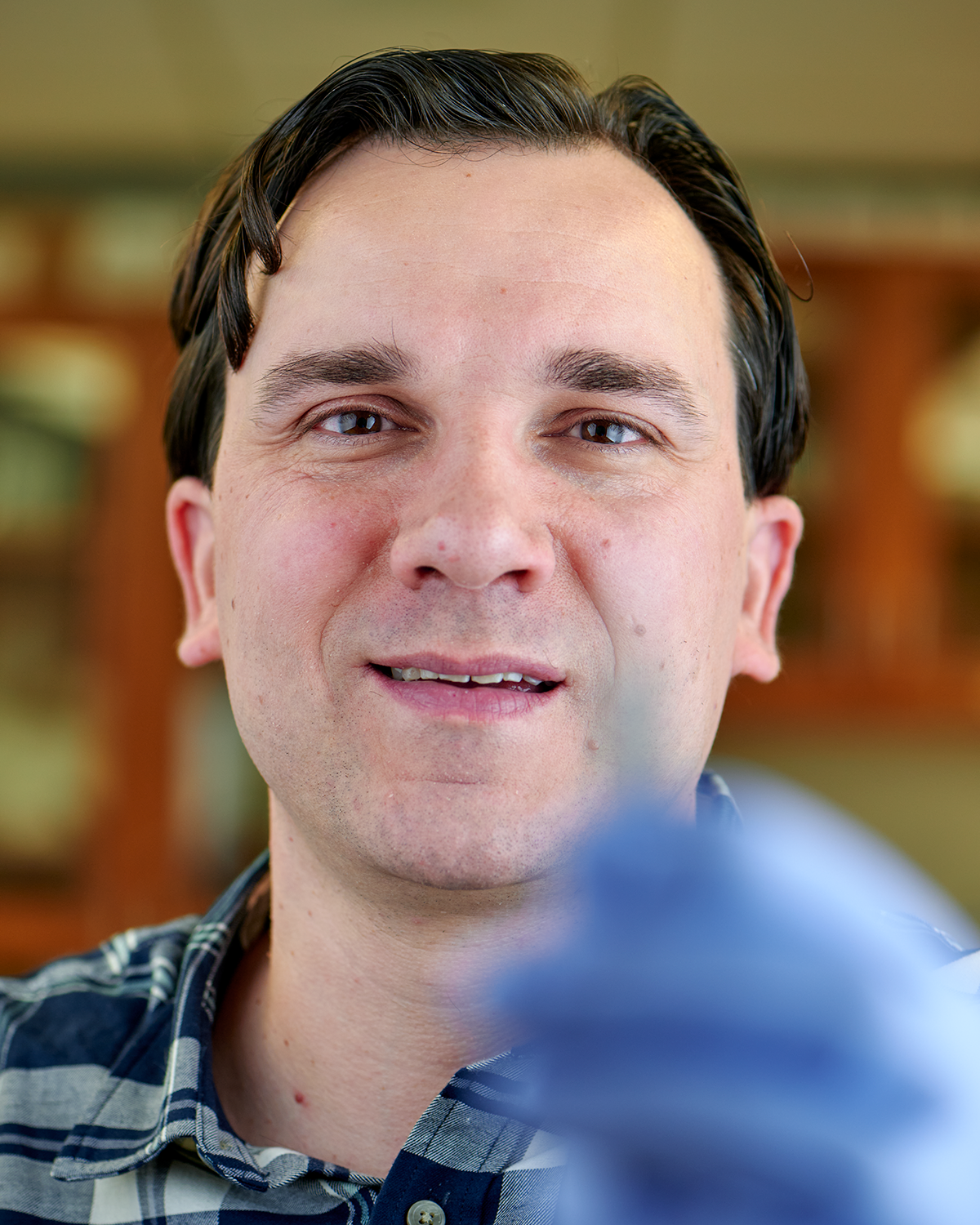 Jeffrey Divino, assistant professor in residence of physiology and neurobiology, holds a fruit fly with forceps at the Torrey Life Sciences Building on Dec. 6, 2023. (Peter Morenus/UConn Photo)