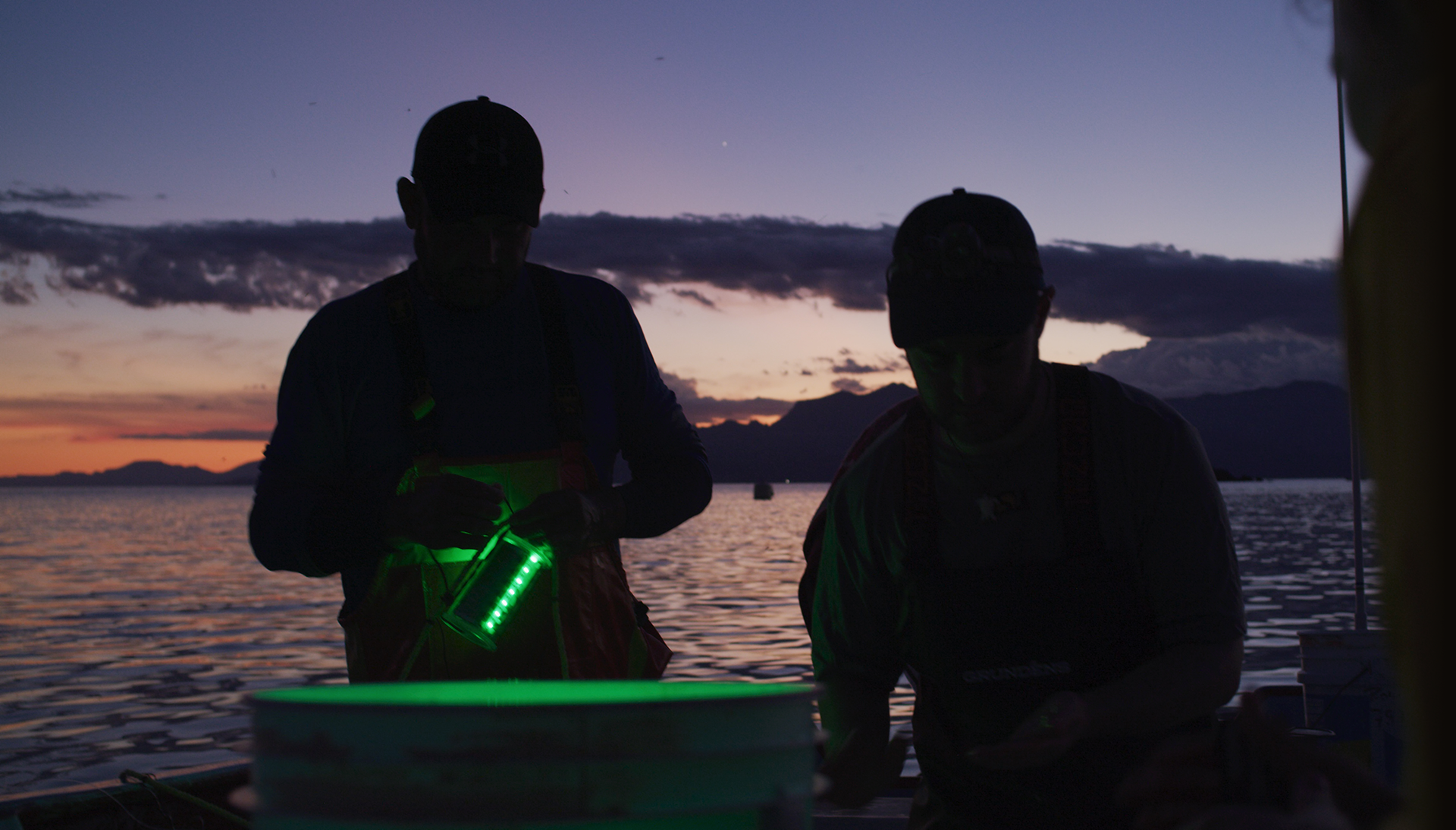 Jesse Senko with another fisherman lay net equipped with lights at nightfall