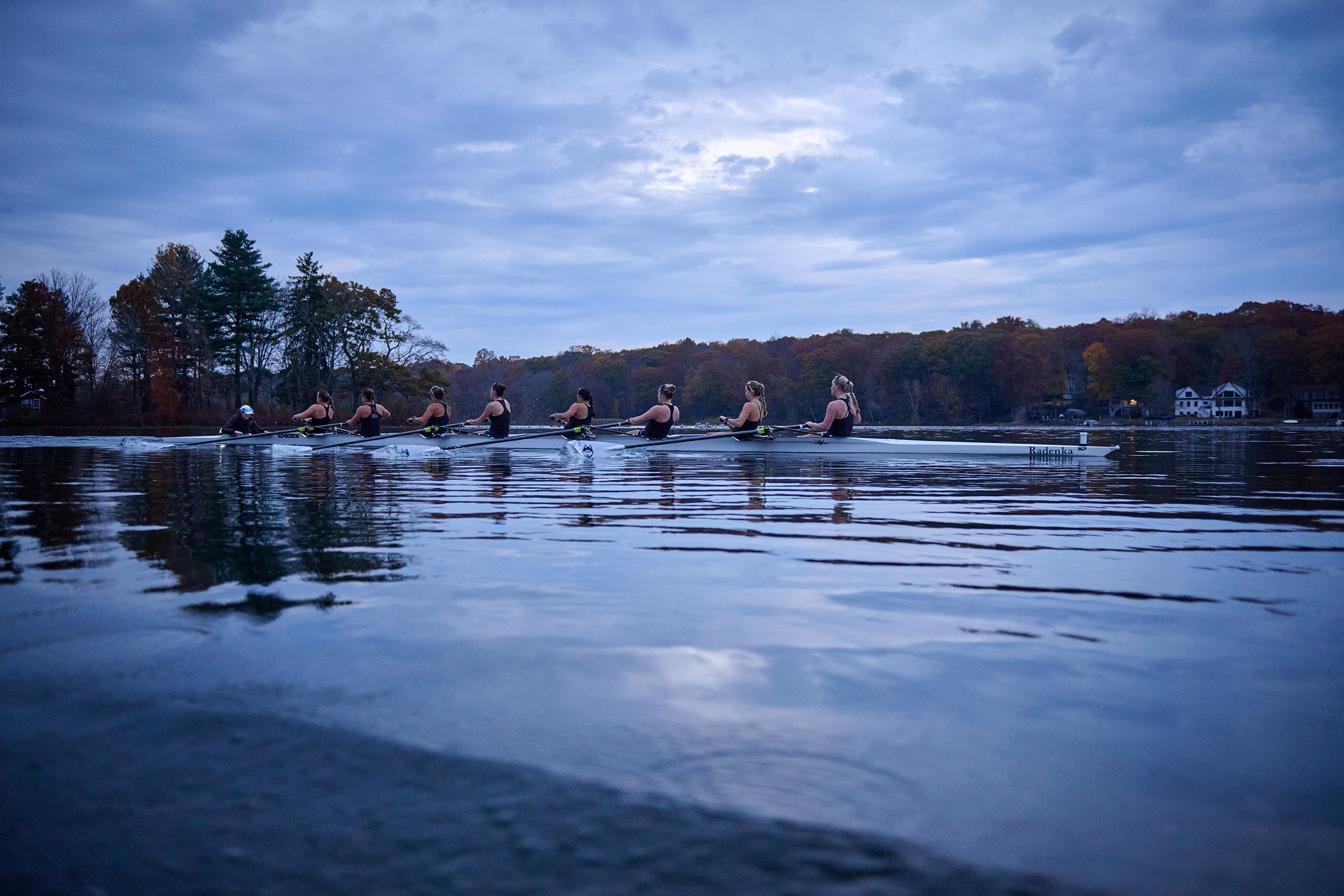 The UConn women's rowing team practices in Coventry Lake in a sleek white boat named Radenka.