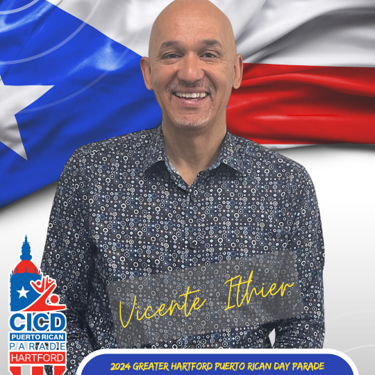 Vicente Ithier in front of Puerto Rican Flag backdrop