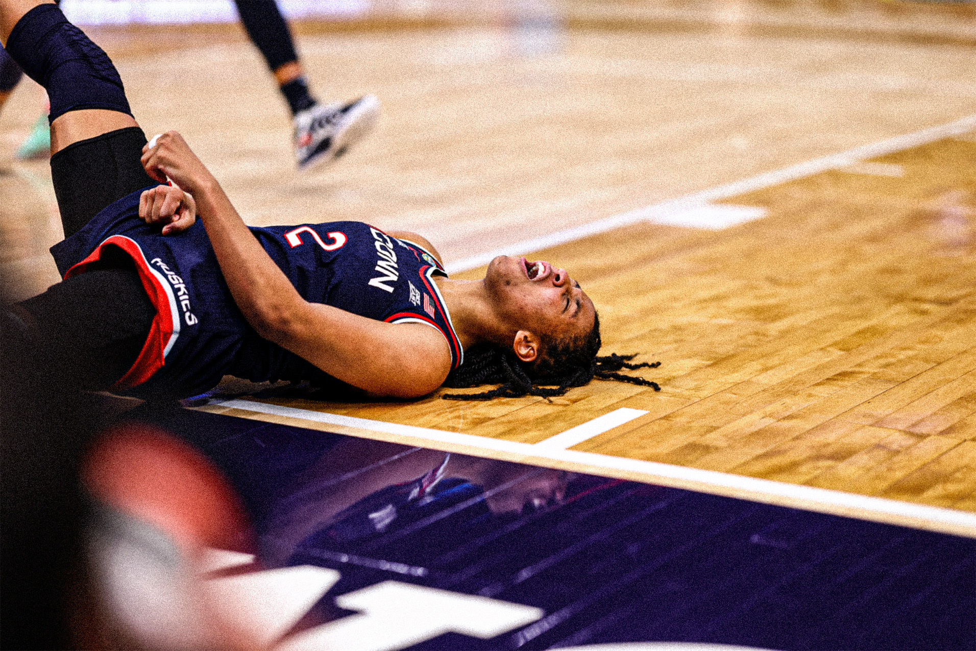 AMB_1704-sized KK Arnold flexes her arms and yells in celebration as she falls on her back after hitting a contested shot at the rim.