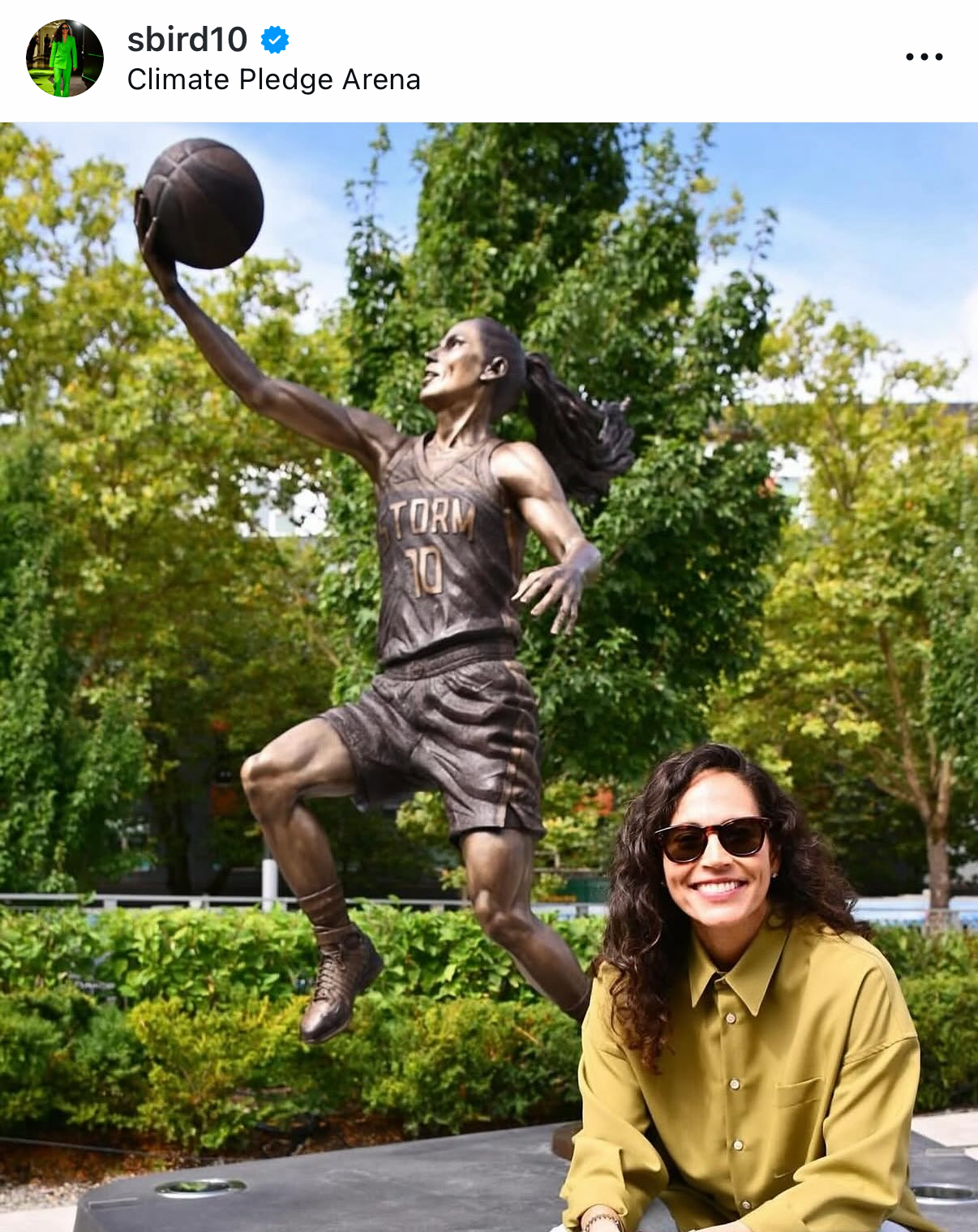 An Instagram post by @sbird10 shows Sue Bird in front of a statue of herself holding a basketball 