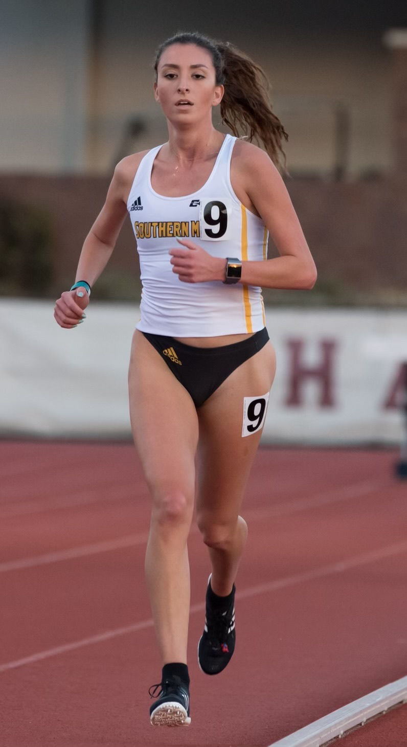 IMG_7955 Vicky Marie Hoppe runs on a track wearing a track uniform with the number 9 on it