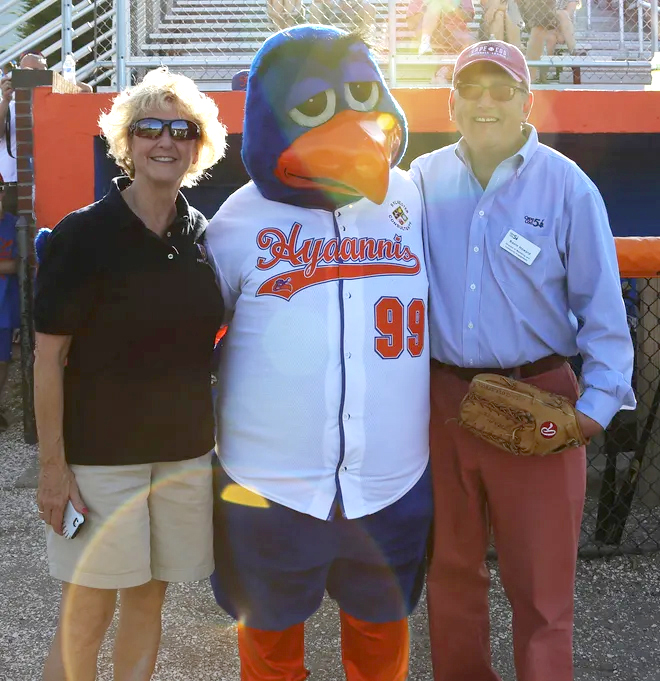 Judy Scarafile poses with the Hyannis Hawks hawk mascot and a man in a Cape Cod ball cap and Cape Cod 5 bank button down shirt