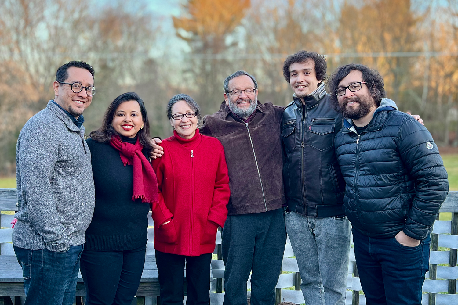 Ortegafamily Morty Ortega and his wife, sons, and daughter-in-law, all wearing light jackets, pose outdoors, smiling at the camera with their arms around each other