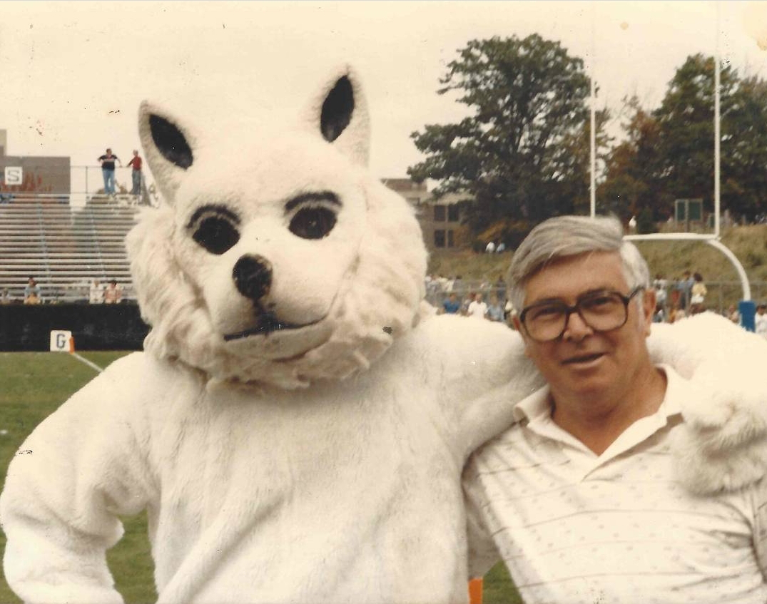 Tim Bartlett wearing the Jonathan the Husky suit with his arm around his grandfather at Memorial Stadium at UConn Storrs in 1986