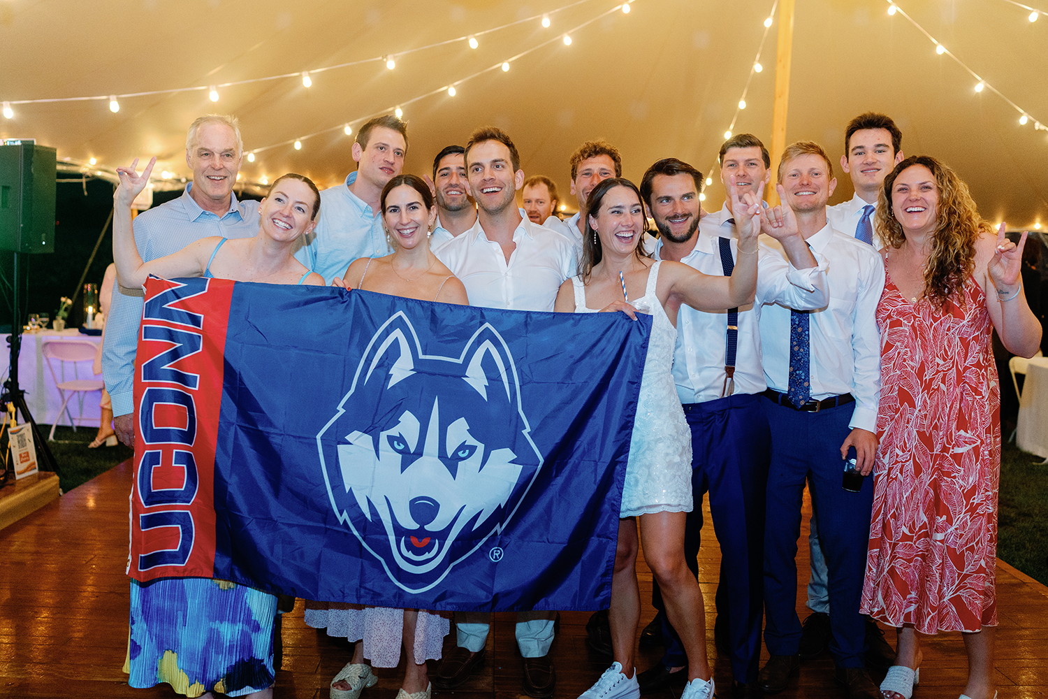A group shot from Emili Burgess' and Kyle Horvath's wedding, which prominently features the UConn flag.